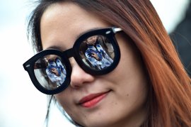 A woman poses in the street before the show for fashion house Fendi at the women Fall/Winter 2015/16 Milan's Fashion Week on Feb. 26, 2015. (GABRIEL BOUYS/AFP/Getty Images)